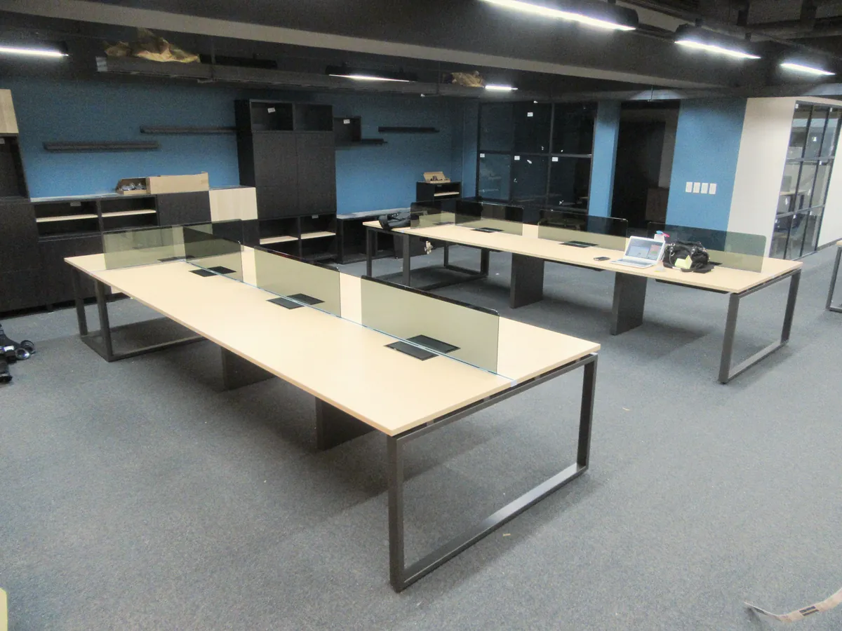Estaciones de trabajo con mamparas de cristal en una oficina abierta