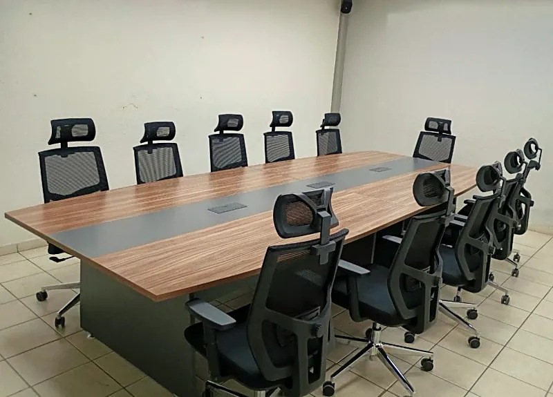 Sala de juntas con mesa para diez personas y sillas ejecutivas de malla